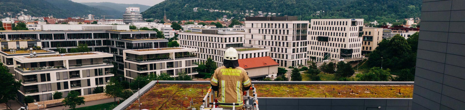 Feuerwehrmann auf Drehleiter blickt über Heidelberg