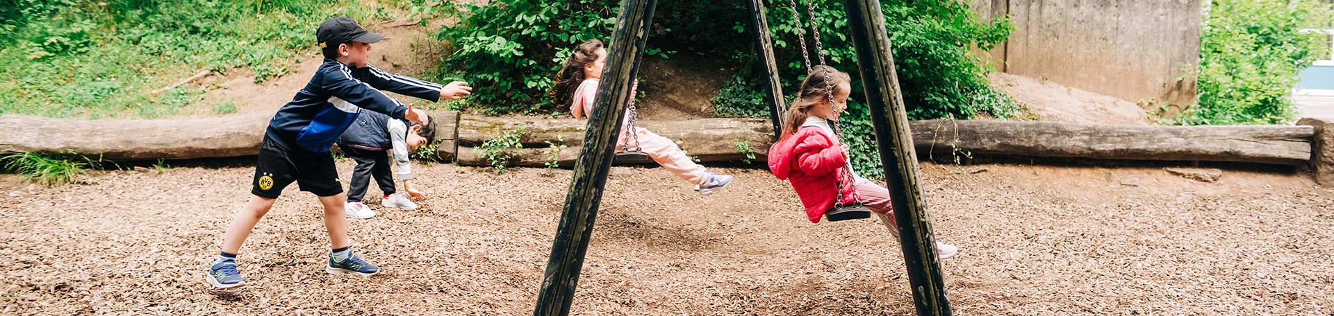 Kinder schaukeln auf einem Spielplatz